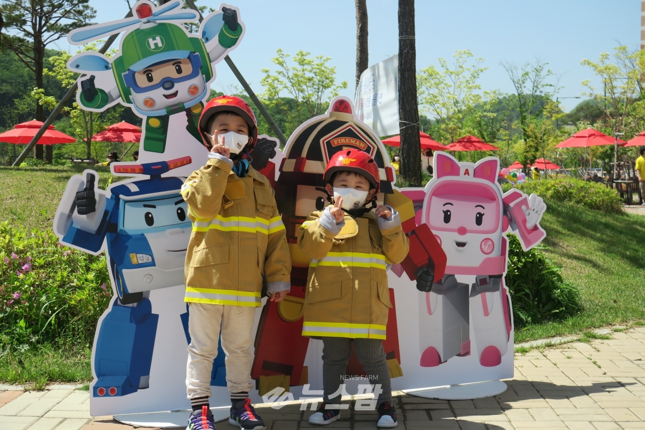 @새빛공원 어린이날 행사장에서 소방복 착용, 로이와 함께하는 포토존에서 사진을 찍고 있다.